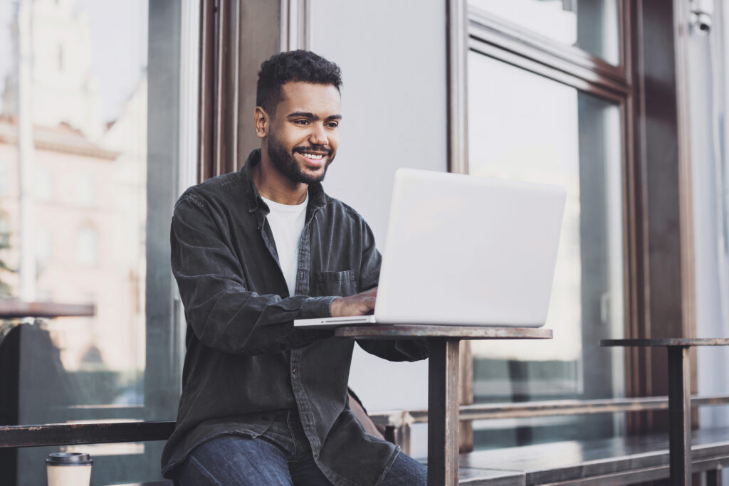 Young handsome man using laptop computer in a city