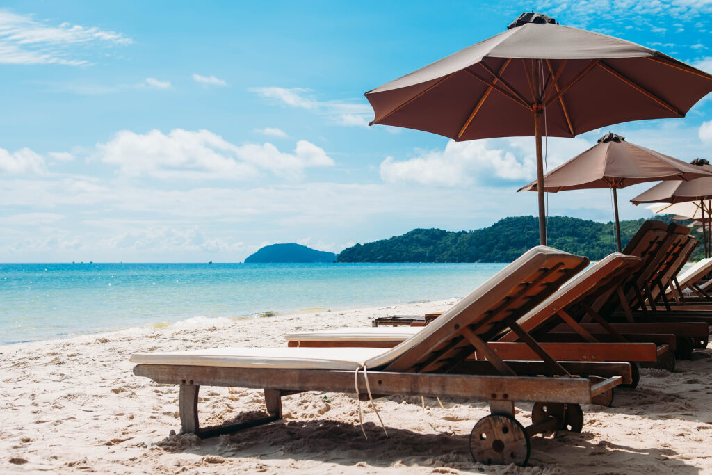 Two lounge chairs with sun umbrella on a beach